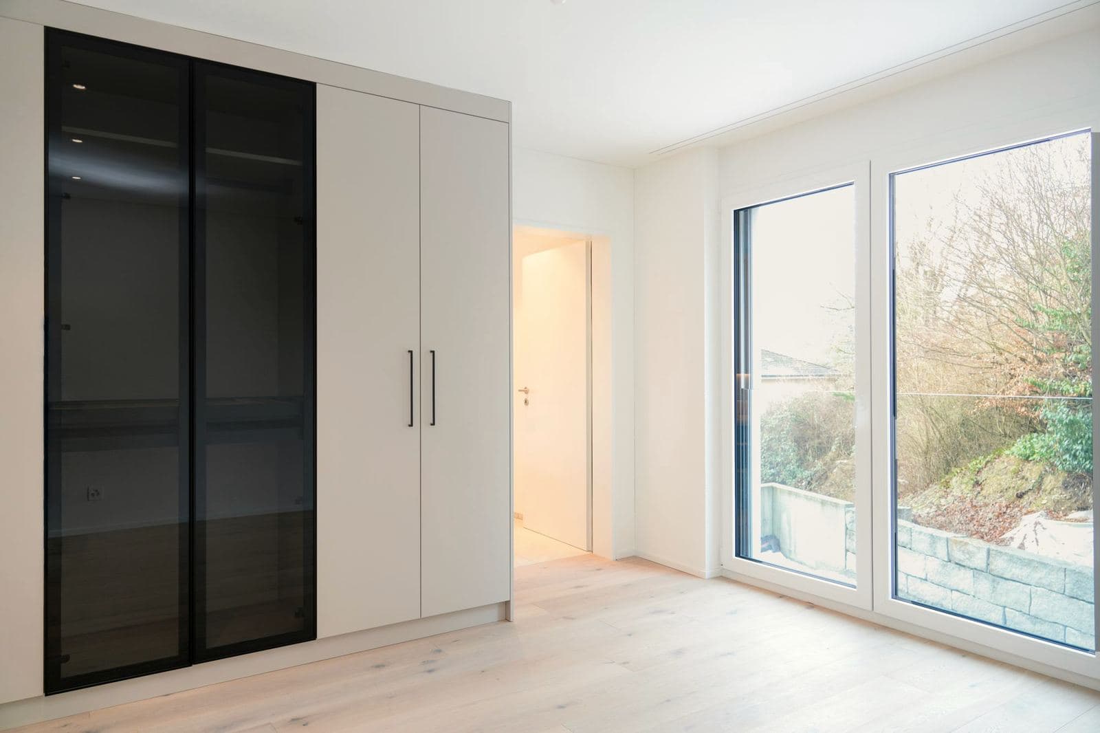 Mehrfamilienhaus: Einbauschrank mit Glasfront am Fenster