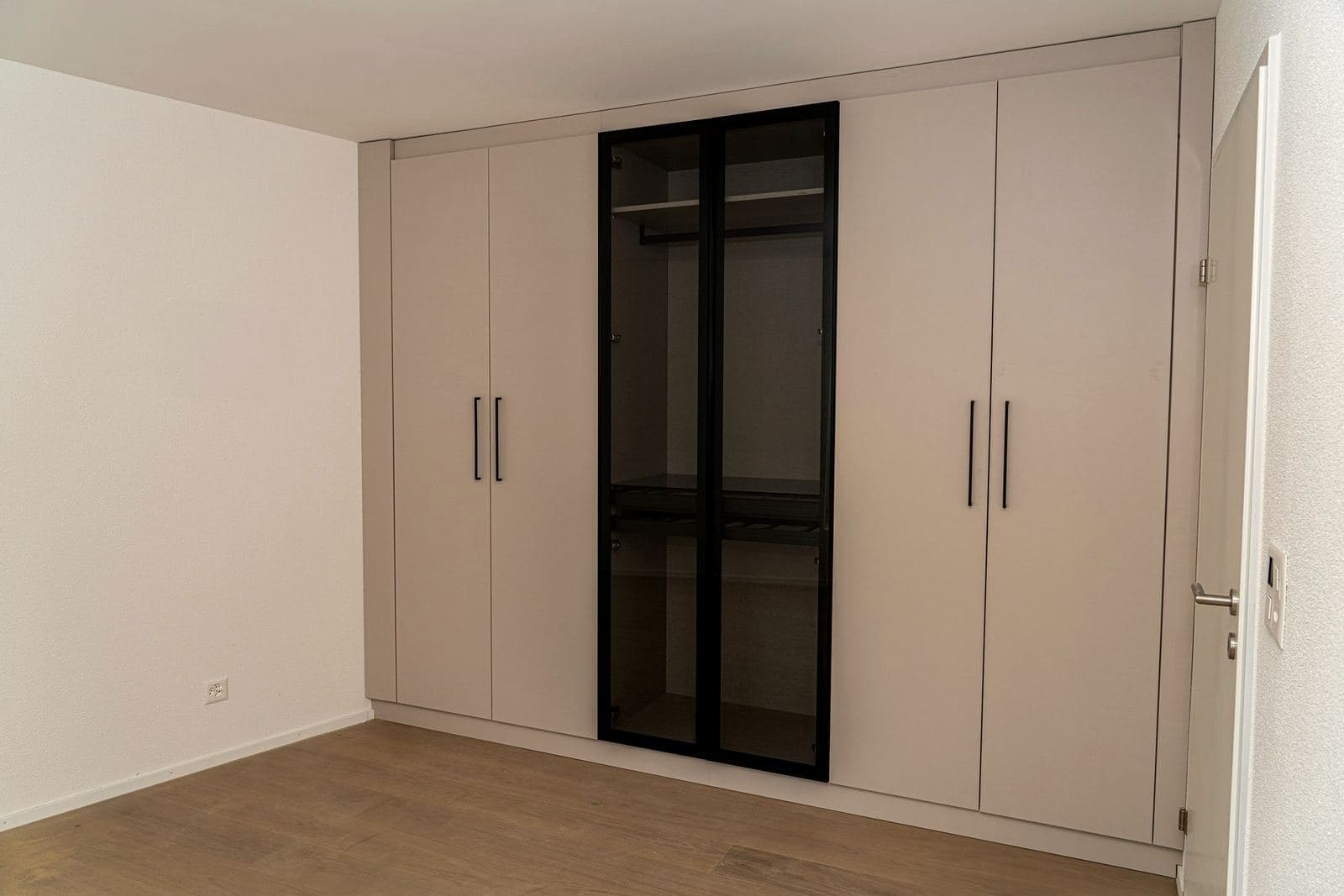 Mehrfamilienhaus: Einbauschrank mit Glasfront im Zimmer